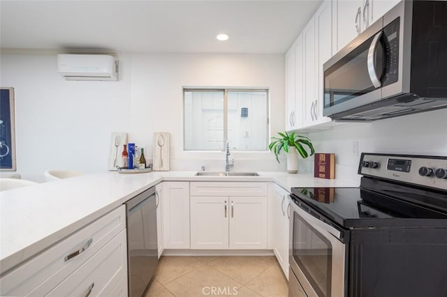 kitchen featuring white cabinets, recessed lighting, appliances with stainless steel finishes, a sink, and a wall mounted air conditioner