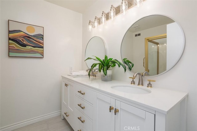 bathroom with baseboards, double vanity, a sink, and visible vents