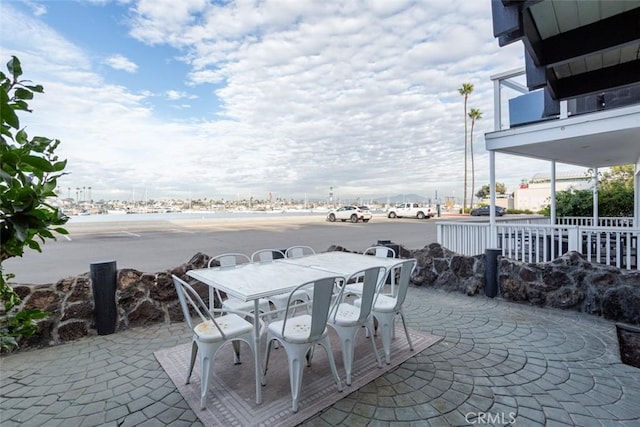 view of patio with outdoor dining area and a water view