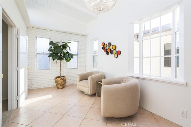 sitting room featuring plenty of natural light, vaulted ceiling with beams, and light tile patterned floors