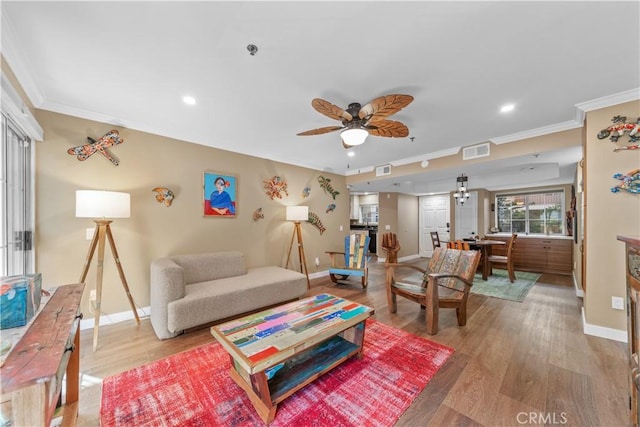 living room featuring light hardwood / wood-style flooring, ceiling fan, and ornamental molding