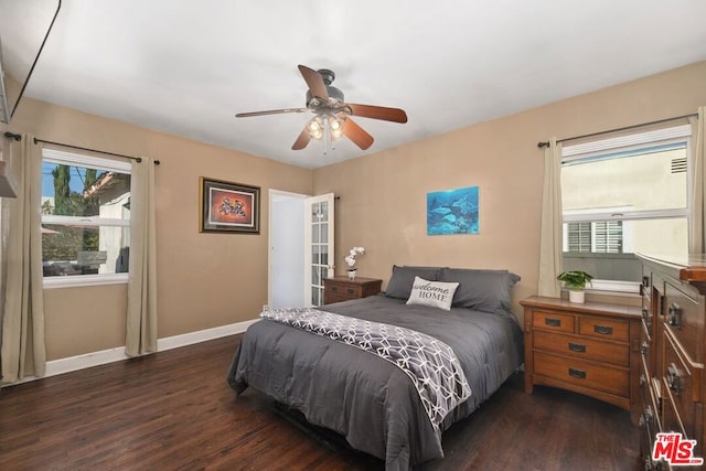 bedroom with ceiling fan, dark wood-type flooring, and multiple windows