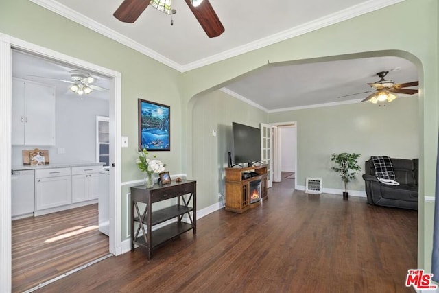 living room featuring ceiling fan, dark wood-type flooring, and ornamental molding