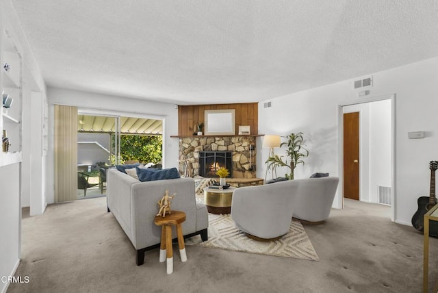 carpeted living room featuring a textured ceiling and a fireplace