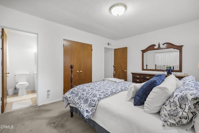 carpeted bedroom featuring connected bathroom and a textured ceiling