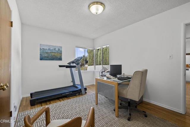 office with hardwood / wood-style floors and a textured ceiling