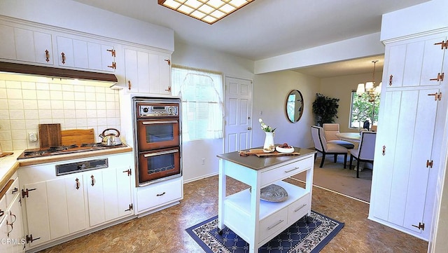 kitchen with plenty of natural light, pendant lighting, white cabinetry, and double wall oven