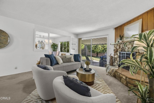 carpeted living room with a fireplace, wood walls, a chandelier, and a textured ceiling