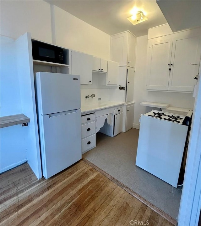 kitchen featuring sink, white appliances, light wood-type flooring, and white cabinets