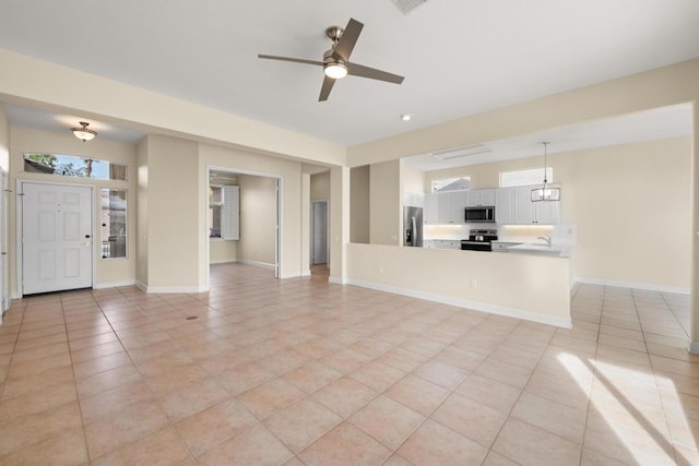 unfurnished living room with ceiling fan and light tile patterned floors