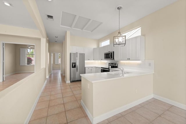 kitchen with white cabinetry, appliances with stainless steel finishes, kitchen peninsula, and light tile patterned flooring