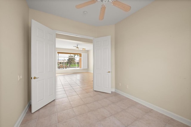 tiled empty room featuring ceiling fan