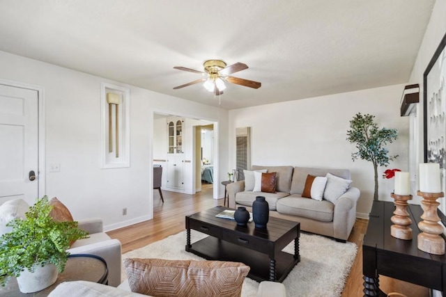 living room with ceiling fan and light hardwood / wood-style flooring