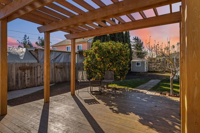 deck at dusk with a shed and a pergola