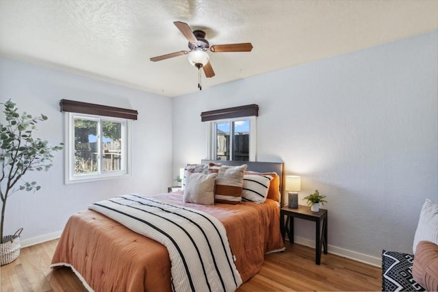 bedroom featuring a textured ceiling, light hardwood / wood-style floors, and ceiling fan