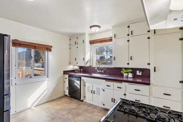 kitchen featuring white cabinetry, sink, dishwashing machine, and stainless steel refrigerator