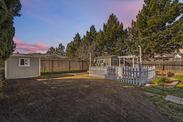 yard at dusk featuring a covered pool and a shed