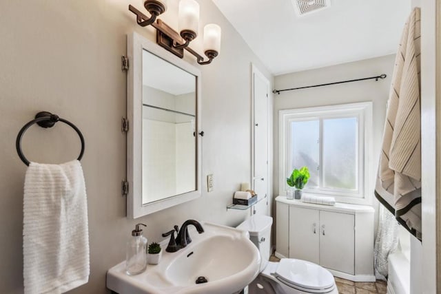 full bathroom with sink, shower / tub combo, and toilet