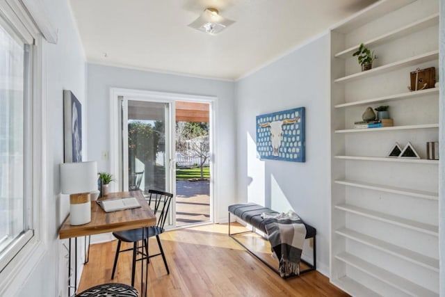 sitting room featuring crown molding, light hardwood / wood-style flooring, and built in features