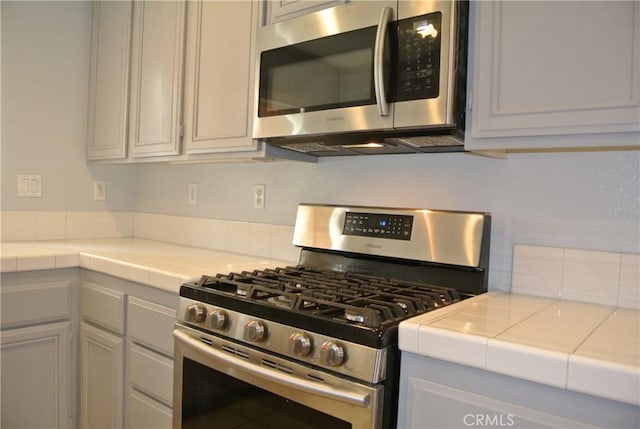 kitchen with stainless steel appliances and tile countertops