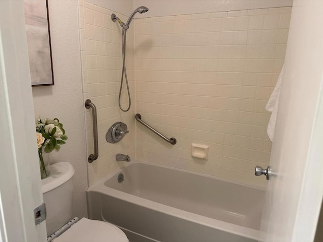 bathroom with tiled shower / bath and toilet