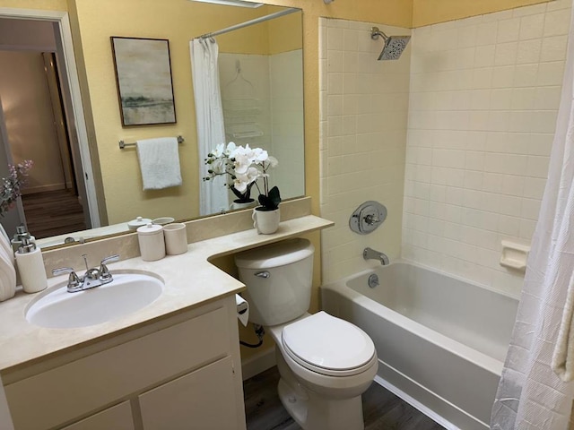 full bathroom featuring hardwood / wood-style flooring, vanity, shower / bath combo with shower curtain, and toilet