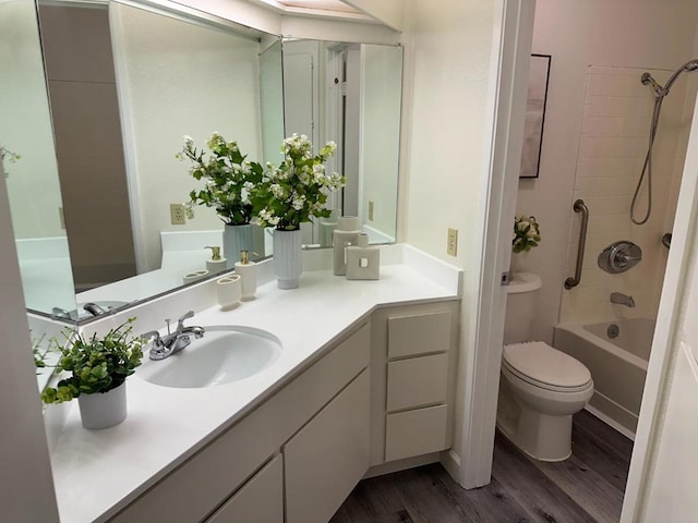 full bathroom featuring vanity, hardwood / wood-style floors, toilet, and tiled shower / bath