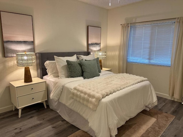 bedroom featuring dark hardwood / wood-style flooring and a textured ceiling