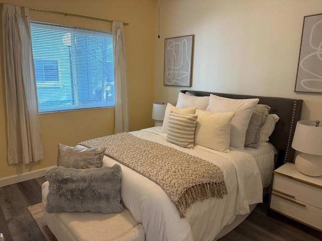 bedroom with dark wood-type flooring and multiple windows