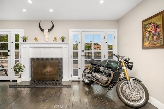 interior space with a tile fireplace, plenty of natural light, and dark hardwood / wood-style floors