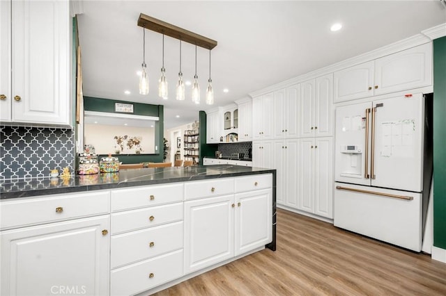 kitchen with high end white fridge, white cabinets, decorative light fixtures, and tasteful backsplash