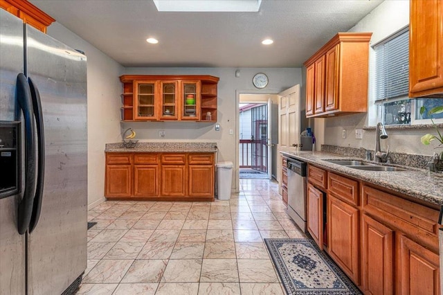 kitchen with light stone counters, sink, and stainless steel appliances