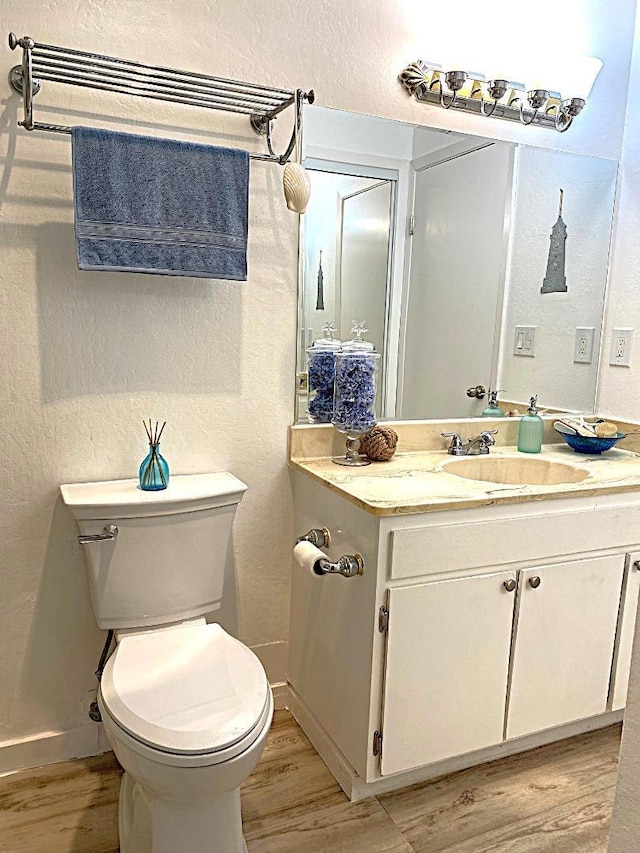 bathroom featuring hardwood / wood-style floors, toilet, and vanity