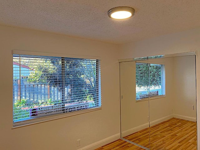 spare room featuring hardwood / wood-style flooring and a textured ceiling