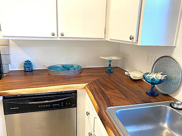 kitchen with sink, white cabinetry, stainless steel dishwasher, and butcher block counters