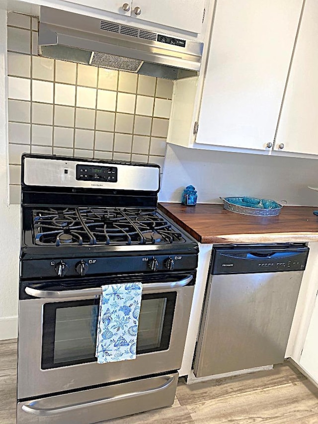 kitchen featuring white cabinets, light hardwood / wood-style flooring, decorative backsplash, and stainless steel appliances