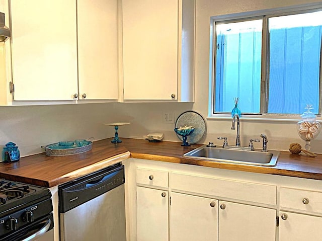 kitchen featuring sink, stainless steel dishwasher, white cabinets, and butcher block countertops