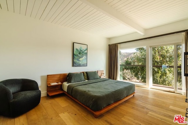 bedroom featuring light hardwood / wood-style floors and beam ceiling