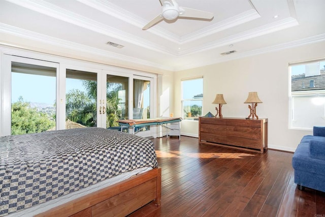 bedroom with ceiling fan, dark wood-type flooring, a tray ceiling, and crown molding