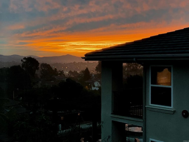 property exterior at dusk with a mountain view