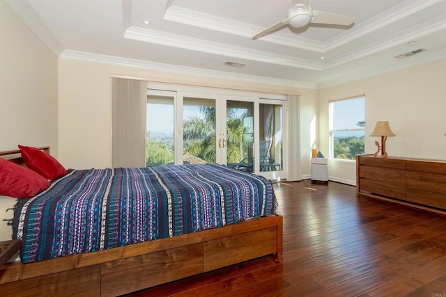 bedroom featuring access to outside, french doors, a raised ceiling, and wood finished floors