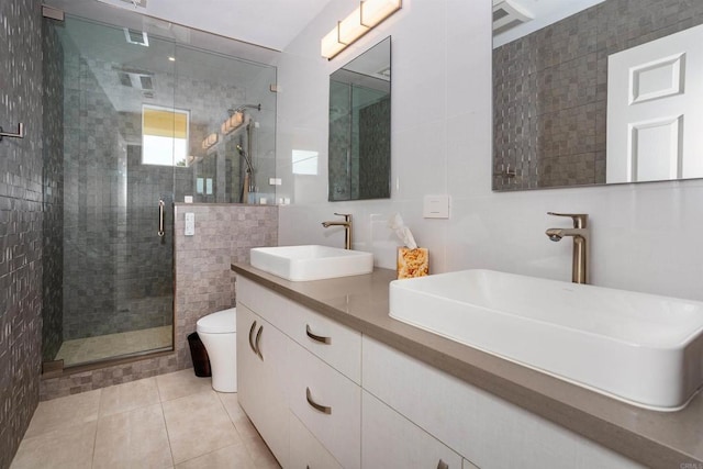 bathroom featuring a sink, toilet, tile walls, and a stall shower