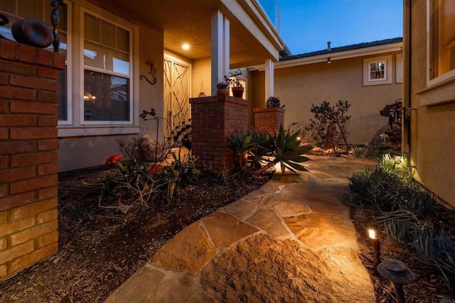 exterior space with stucco siding and a patio