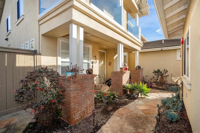 entrance to property with fence and stucco siding