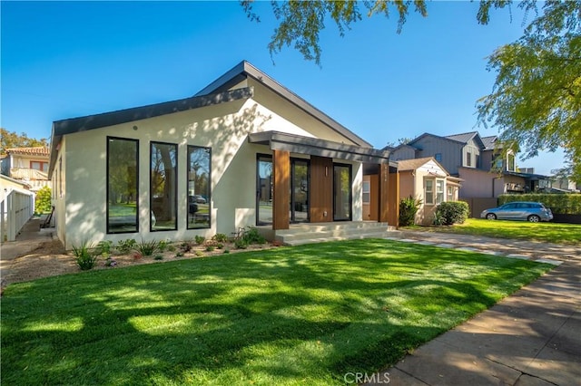 view of front of property featuring a front lawn and stucco siding