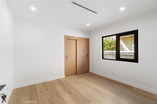 unfurnished bedroom featuring recessed lighting, light wood-style flooring, and baseboards