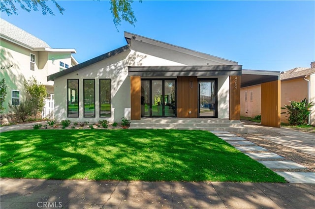 back of house with a lawn and stucco siding