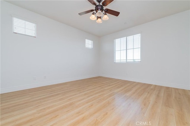 spare room with ceiling fan, a wealth of natural light, and light hardwood / wood-style flooring