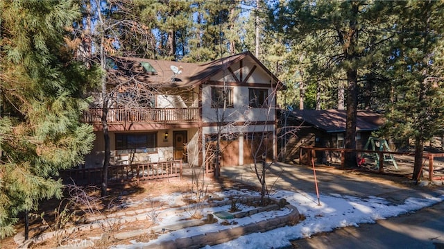 41984 Mapleleaf Dr, Big Bear Lake, CA 92315 - rustic home featuring concrete driveway, an attached garage, stucco siding, and a deck