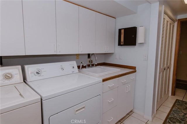 laundry room with sink, cabinets, washing machine and dryer, and light tile patterned floors